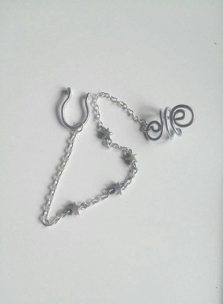 Handmade Star Septum Nose to Ear Chain with silver metallic star beads - Body Jewelry - No piercing nose required (fake nose ring)- Ring Adaptable, Fake septum, you can wear it without a nose piercing - The chain is approximately 13cm long and is only 3mm wide, which is so tiny - Hoop Nose Made from 16 gauge aluminium wire non-tarnish and antiallergenic - Each piece is created by hand, giving it a unique charm. ***************************************************************************************** Each piece is handcrafted using thick, anodized aluminium wire. Important Note: To keep the ring in perfect condition is important to know how to open and close our ring properly; look for the opening of the ring and place the fingers of each hand on each side of the opening and make a sideways movement with each hand in a reverse direction